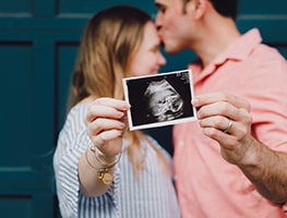 Happy pregnant couple showing an ultrasound picture