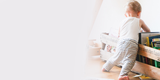 Baby looking into a bookshelf
