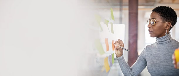 Woman writing on sticky notes on a board