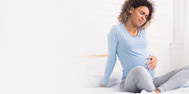 Pregnant woman in pain holding her stomach